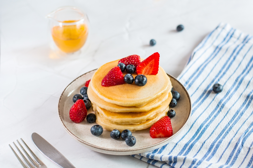Pancakes,With,Fresh,Berries,,Mint,And,Maple,Syrup,On,White