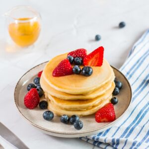 Pancakes,With,Fresh,Berries,,Mint,And,Maple,Syrup,On,White
